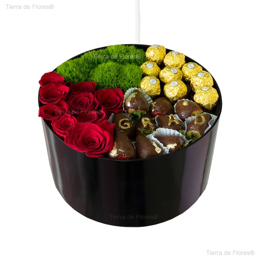 arreglo floral en caja negra vista desde arriba con rosas rojas chocolates ferrero frutillas con chocolate