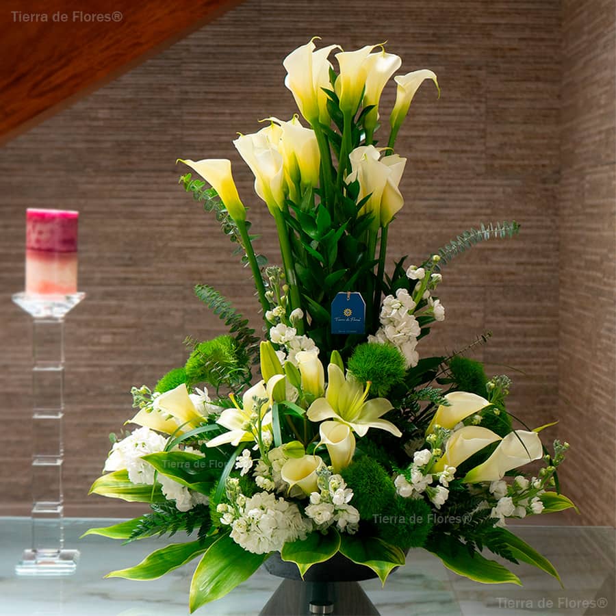 arreglo floral alargado con flores cartuchos y mas flores blancas como lirios